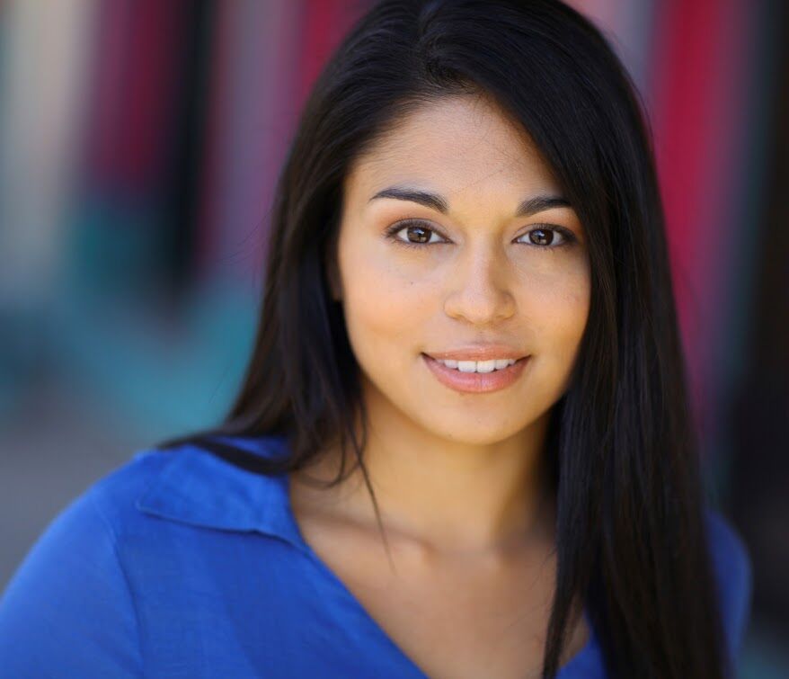 Portrait of a woman with long dark hair smiling gently.